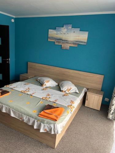 a bedroom with a large bed with a blue wall at CASA DAVID in Dubova