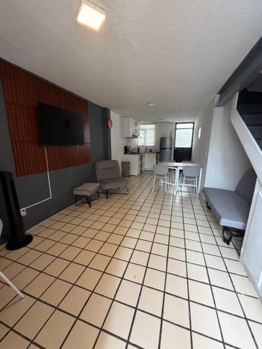 ein Zimmer mit Tisch und Stühlen und einer Küche in der Unterkunft Casa Torremolinos en Coto Privado in Zapopan