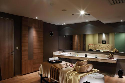 a bathroom with a bed and a sink and a mirror at Holiday Inn Bandung Pasteur, an IHG Hotel in Bandung