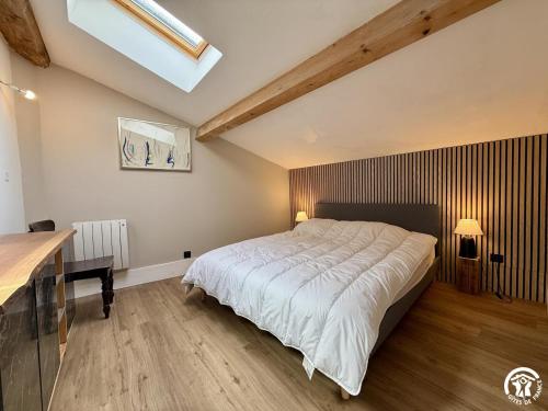a bedroom with a large bed and a wooden floor at Le gîte du clos in Roquefort-des-Corbières