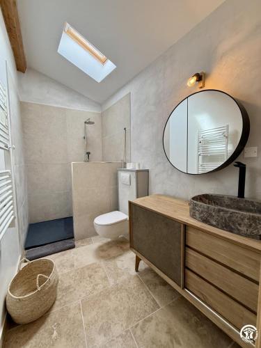 a bathroom with a sink and a toilet and a mirror at Le gîte du clos in Roquefort-des-Corbières