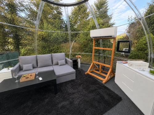 a living room with a couch in a glass house at Skyhomes Bubble Hotel in Prague