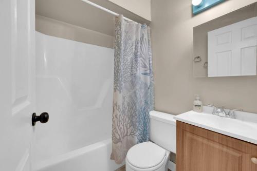 a bathroom with a toilet and a sink and a shower curtain at Between Tides 2BR Walk to Beach Unit C in Seaside Park