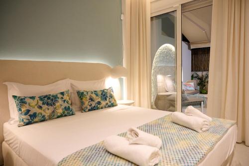 a bedroom with a bed with towels on it at Perea Fiore Suites in Perea