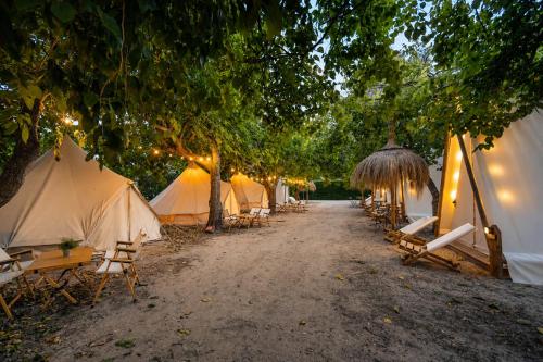 a row of tents with tables and chairs and lights at Kampaoh Paloma in Tarifa