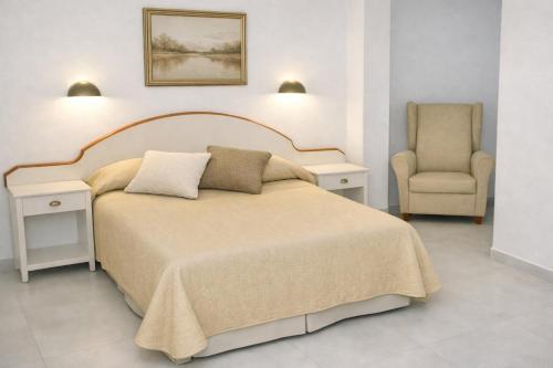 ein Schlafzimmer mit einem großen Bett und einem Stuhl in der Unterkunft Hostal J.B in Malpica