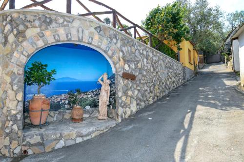a stone wall with an arch with a statue on it at Casa Vacanze Chery in Sorrento