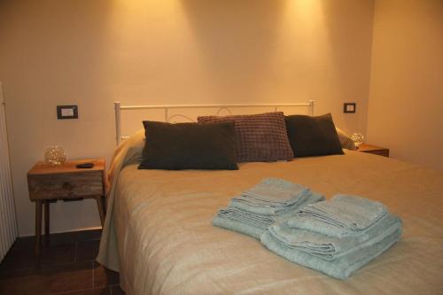 a bed with towels on top of it with a table at Il nido di Acqui in Acqui Terme