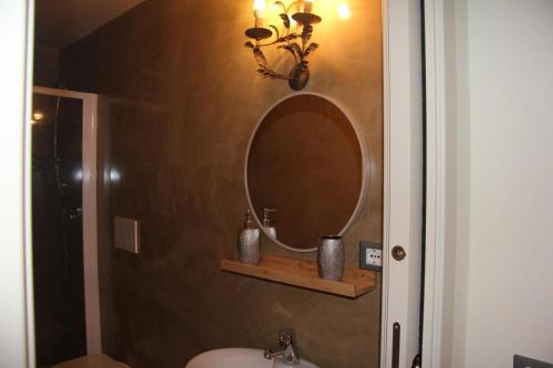 a bathroom with a mirror and a sink at Il nido di Acqui in Acqui Terme