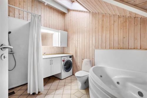 a bathroom with a toilet and a washing machine at LN1600-Hjorring-Indemarken-36 in Hjørring