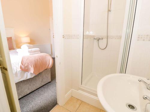 a bathroom with a shower and a sink and a tub at The Causeway in Llandudno