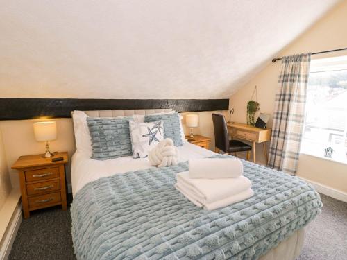 a bedroom with a bed with towels on it at The Causeway in Llandudno