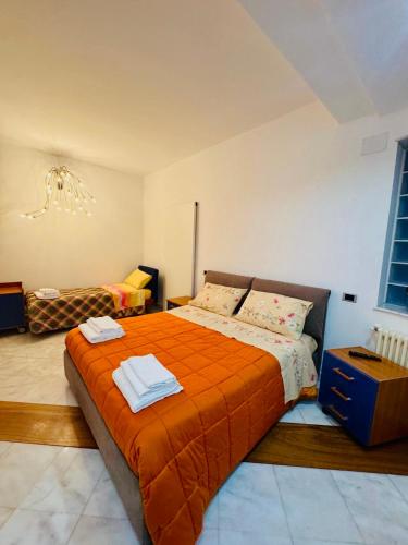 a bedroom with a large bed with an orange blanket at Dejavu ROOMS & SPA in Assoro