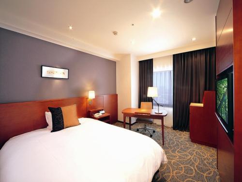 a hotel room with a bed and a television at Akita Castle Hotel in Akita