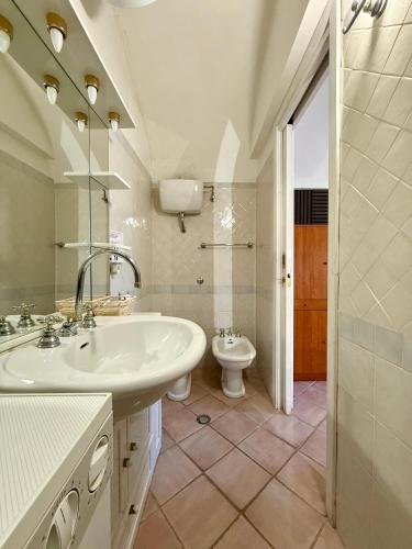a white bathroom with a sink and a toilet at Casa Paulina in Scanno