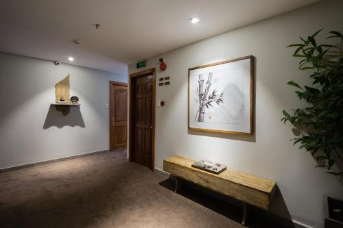 a room with a bench and a picture on the wall at Silverland Yen Hotel in Ho Chi Minh City