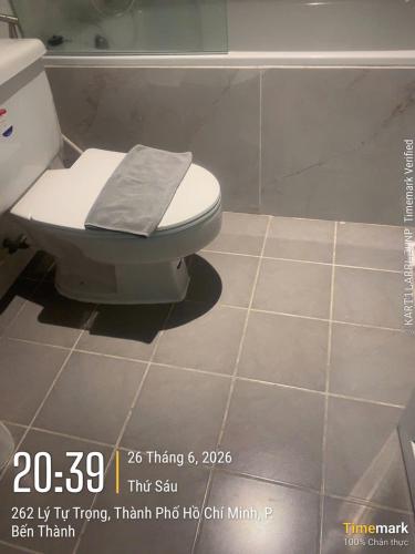 a bathroom with a toilet with a towel on it at Financeer Hotel in Ho Chi Minh City