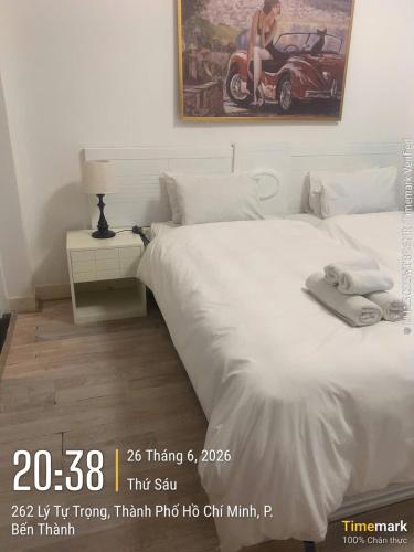 a bedroom with a white bed with a picture of a car at Financeer Hotel in Ho Chi Minh City