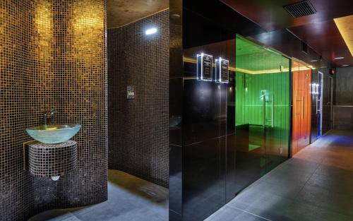 a bathroom with a sink and a green shower at Apartio Bella in Vysoké Tatry