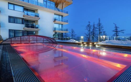 a swimming pool with red lights in front of a building at Apartio Bella in Vysoké Tatry