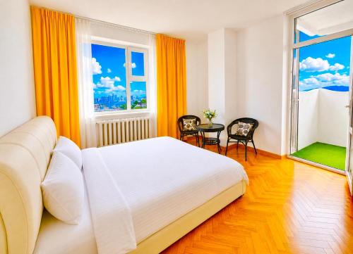 a bedroom with a bed and two chairs and a window at Yura Hostel in Darhan