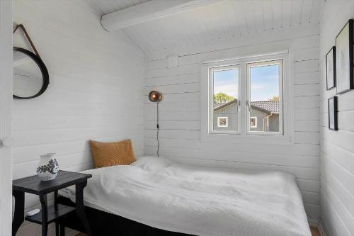 a white bedroom with a bed and a window at SJ291-Hejls-Brombaervaenget-36 in Hejls