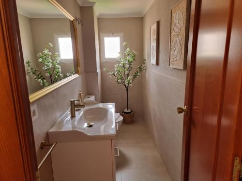 a bathroom with a sink and a toilet and a mirror at MD Villa con piscina en Mareny Beach in Mareny Blau