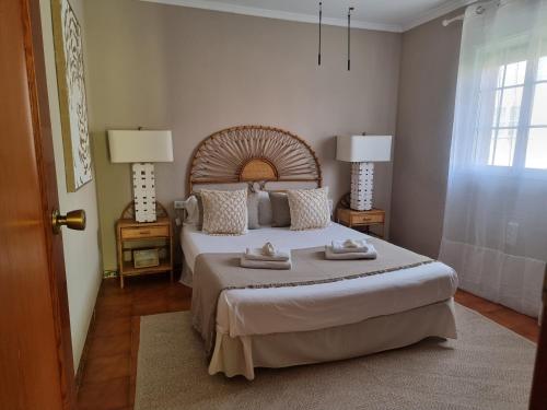 a bedroom with a large bed and two lamps at MD Villa con piscina en Mareny Beach in Mareny Blau