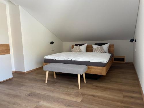 a bedroom with a bed and a bench in it at Apartment Bienenfresser in Vogtsburg
