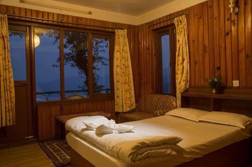 a bedroom with a bed and a large window at Hotel Galaxy View Tower in Nagarkot