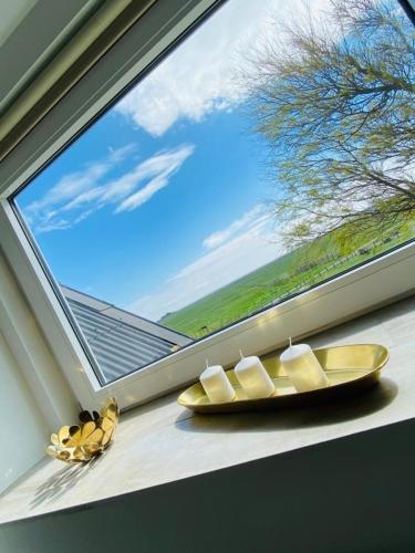a window with a yellow plate on a window sill at HaRE Ferienwohnung DREE in Langeneß