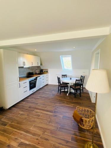 a kitchen and dining room with a table and chairs at HaRE Ferienwohnung DREE in Langeneß