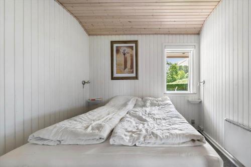 a bed in a white room with a window at SJ290-Hejls-Ae-Skovbryn-2 in Hejls