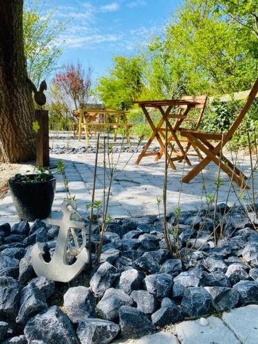 a rock garden with a bench and a table at HaRE Ferienwohnung twee in Langeneß