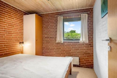 a bedroom with a bed and a brick wall at SJ300-Haderslev-Vikaerparken-87 in Haderslev