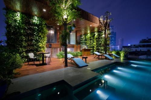 un patio trasero con piscina por la noche en Silverland Yen Hotel en Ho Chi Minh