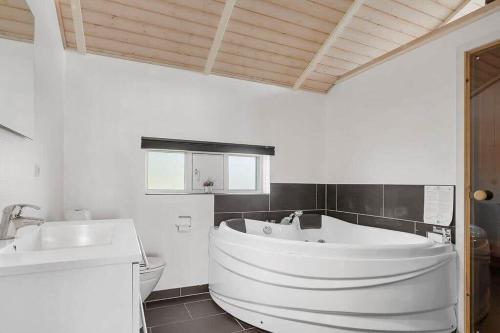 a white bathroom with a tub and a sink at SJ301-Hejls-Teglgardsvej-3 in Hejls