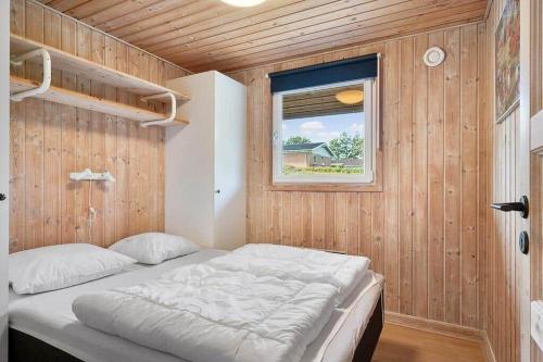 a bedroom with a bed in a wooden wall at SJ310-Hejls-Ronnebaervaenget-14 in Hejls