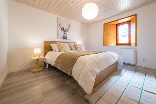 a bedroom with a large bed and a window at Renovated Triplex House 8 guests Orelle in Orelle