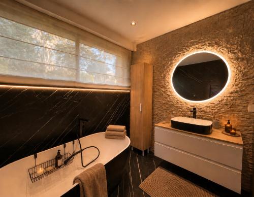 a bathroom with a tub and a sink and a mirror at Superbe Villa très proche cannes in Mougins