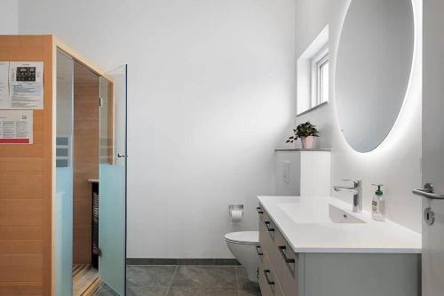 a bathroom with a sink and a toilet and a mirror at SJ313-Borkop-Sommerhaven-38 in Mørkholt