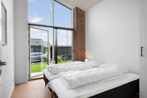 a bed with white pillows in a room with a window at SJ313-Borkop-Sommerhaven-38 in Mørkholt