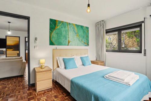 ein Schlafzimmer mit einem blau-weißen Bett und einer Couch in der Unterkunft Cantinho Do Préstimo in Águeda
