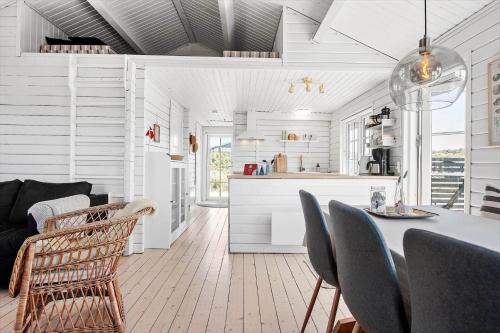 a kitchen and living room with a table and chairs at LN1883-Hjorring-Revlingrenden-13 in Hjørring