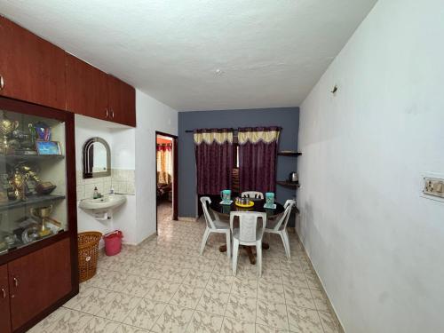a kitchen with a table and chairs in a room at DD cottages in Ooty