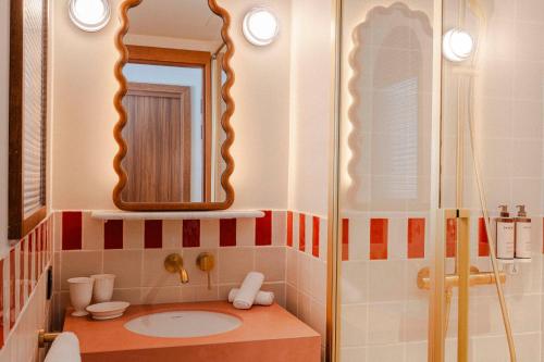 a bathroom with a sink and a mirror at Posidonia Hôtel in Nice