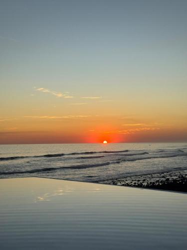 a sunset on the beach with the ocean at Oceanfront Villa, Punta Mango in Jucuarán