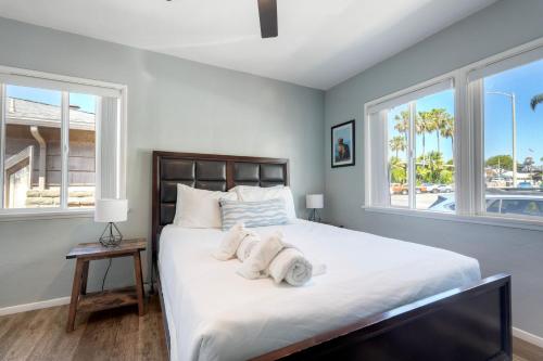 a bedroom with a large bed with towels on it at Oceanfront unit, Private Balcony, Beach Access, Sunset Views in Carlsbad