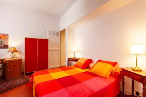 a bedroom with a colorful bed and a red cabinet at Chambres D'hôtes Chez Marie in Marseille