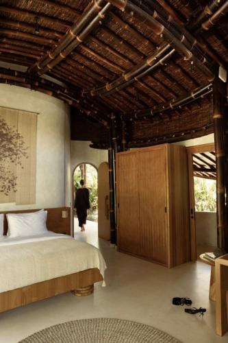 a bedroom with a bed and a person walking into it at Kaymana in Uluwatu